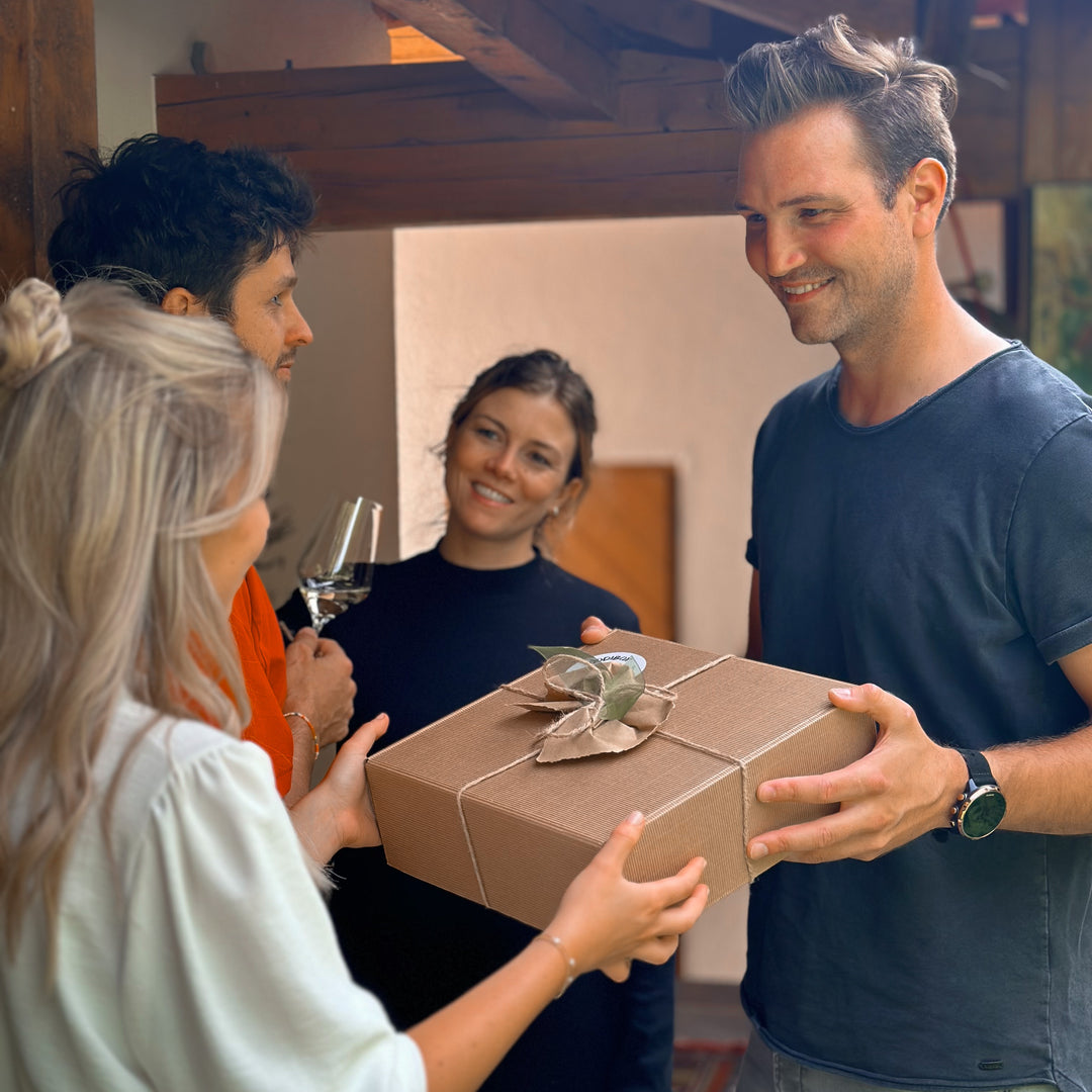 Bild mit zwei Pärchen bei der Übergabe eines Geschenkes