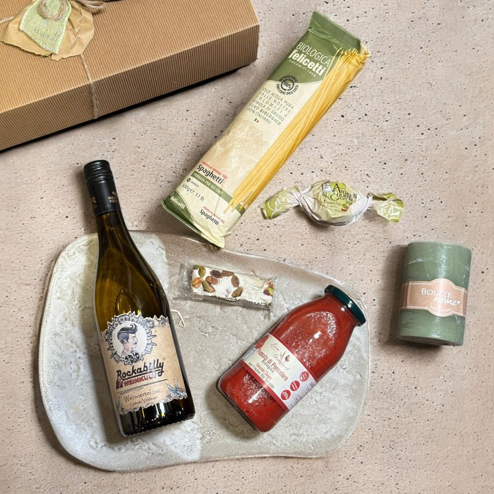 Ausgepackte Geschenkbox mit Rockabilly Grüner Veltliner Felicetti Spaghetti Passata Nougat Stick und Stumpenkerze