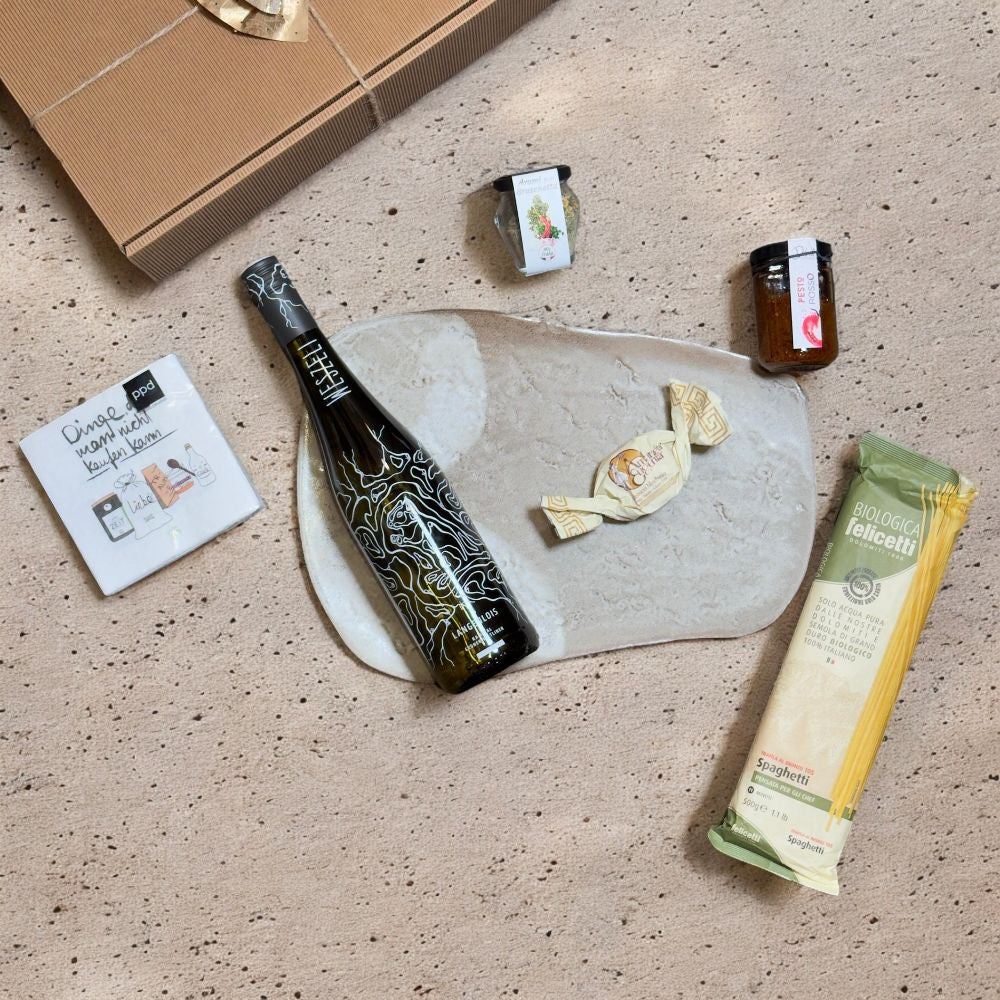 Ausgepackte Geschenkbox mit Rockabilly Gruner Veltliner Felicetti Spaghetti Passata Nougat Stick und Stumpenkerze