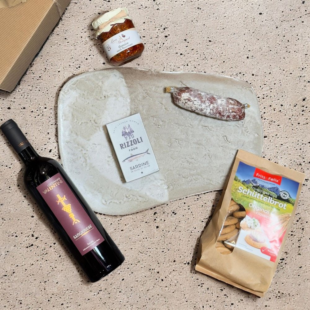 Ausgepackte Italienische Feinkost Geschenkbox mit Valentini Sangiovese Wein Rizzoli Sardinen Fritz & Felix Schüttelbrot Live & Gourmet Gemüse und Jägersalami