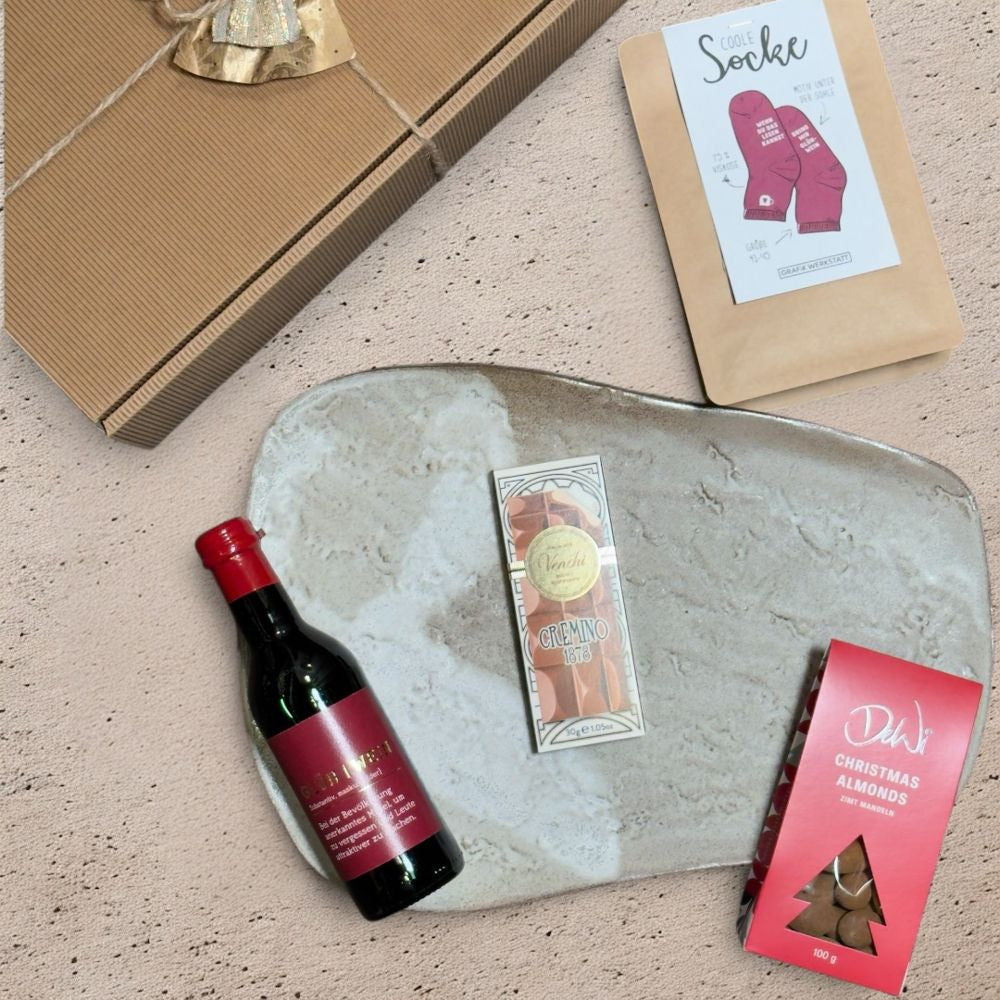 Ausgepackte Glühwein Geschenkbox mit Grafik Werkstatt Glühwein Flasche Coole Socke Größe 41 bis 45 DeWi Zimt Mandeln und Venchi Cremino Schokolade