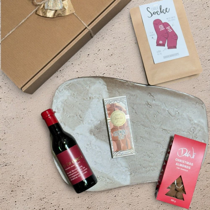 Ausgepackte Glühwein Geschenkbox mit Grafik Werkstatt Glühwein Flasche Coole Socke Größe 41 bis 45 DeWi Zimt Mandeln und Venchi Cremino Schokolade
