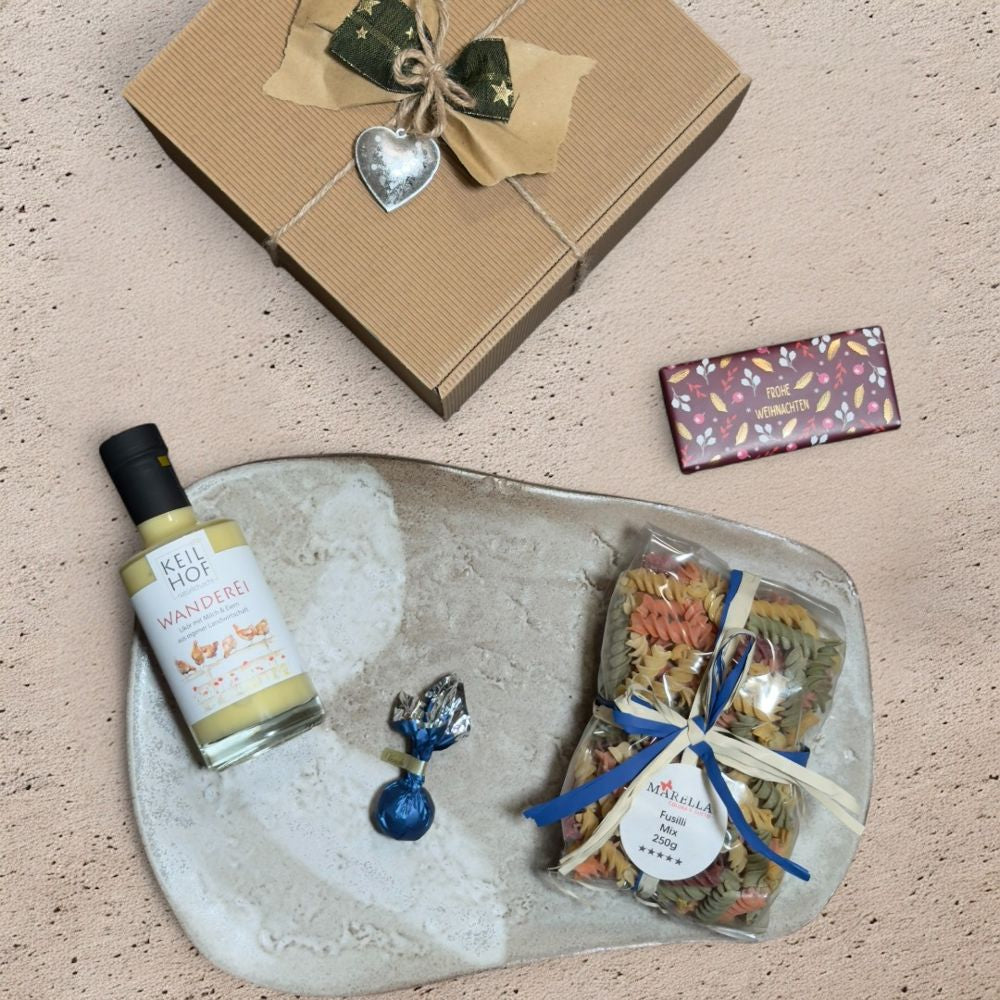 Ausgepacktes Weihnachtsgeschenk Eierlikör mit Keilhof Wanderei Eierlikör Venchi rote goldene Weihnachtskometen Grafik Werkstatt Schokolade Marella Fusilli Mix und Metall Weihnachtsmotiven