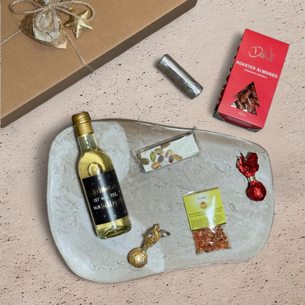 Ausgepackte Weihnachtsmarkt Geschenkbox mit Grafik Werkstatt Glühwein DeWi gebrannte Mandeln Soft Nougat Stick Pistazie Venchi Weihnachtskometen Floga Räucherkohle und Metall Weihnachtsmotiven