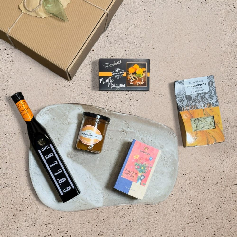 Ausgepackte Marillen Geschenkbox mit Sonnentor Dankeschön Kräutertee Gölles Marillen Essig 250 ml Floberry Bergmarillen Mamelad 200g Fenkart Marille Marzipan Edelbitterschokolade 80g und SteirerKraft Kürbiskerne Weiße Schokolade Selection 100g